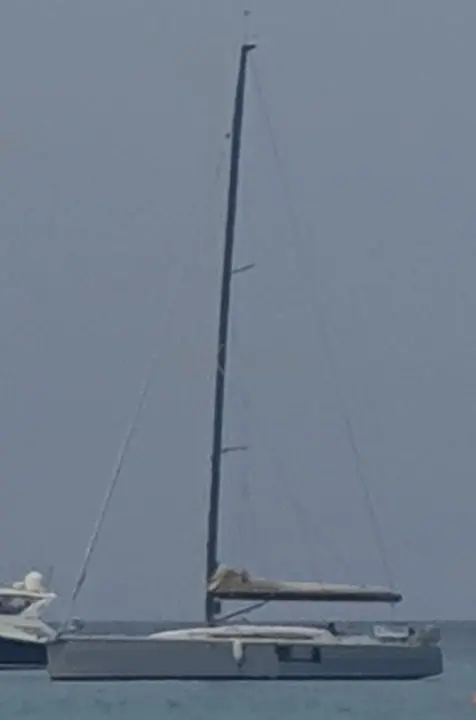 Sly Yachts Sly 42 — Voilier vu de profil sur l’eau, avec un autre bateau partiellement visible à gauche.