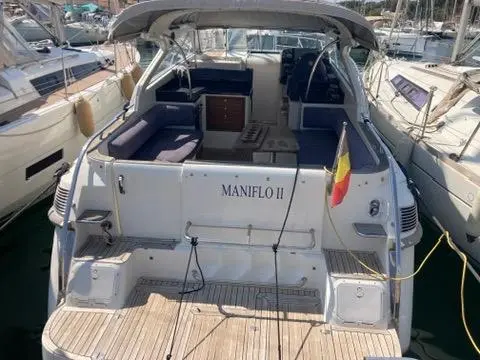 Marex 350 Cabriolet Cruiser — Vue arrière d’un bateau à moteur amarré, avec cockpit ouvert et pavillon belge.