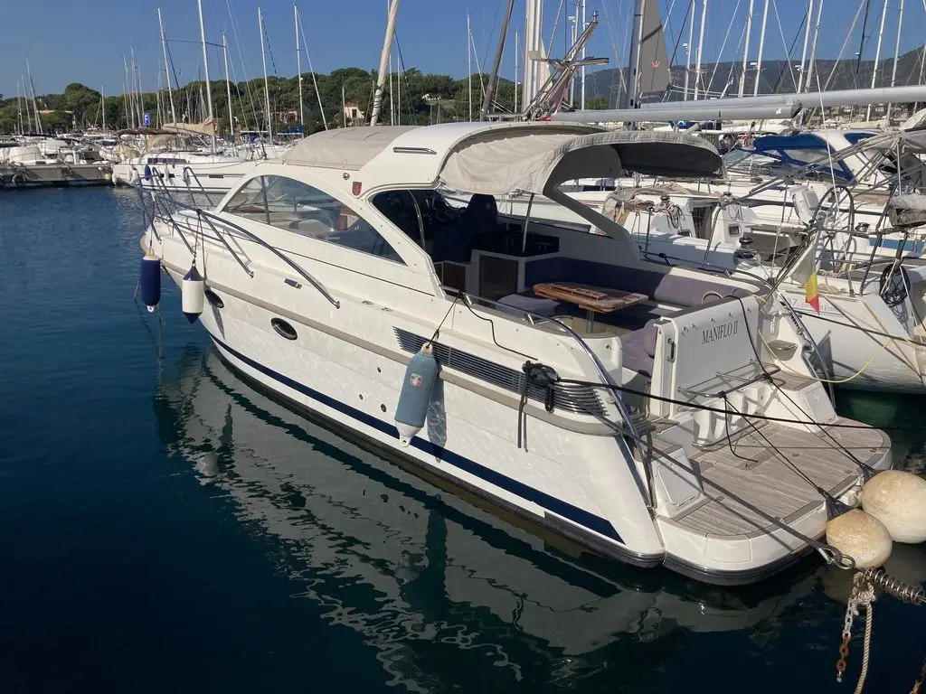 Marex 350 Cabriolet Cruiser — Bateau à moteur blanc amarré dans une marina, vu de trois quarts arrière.