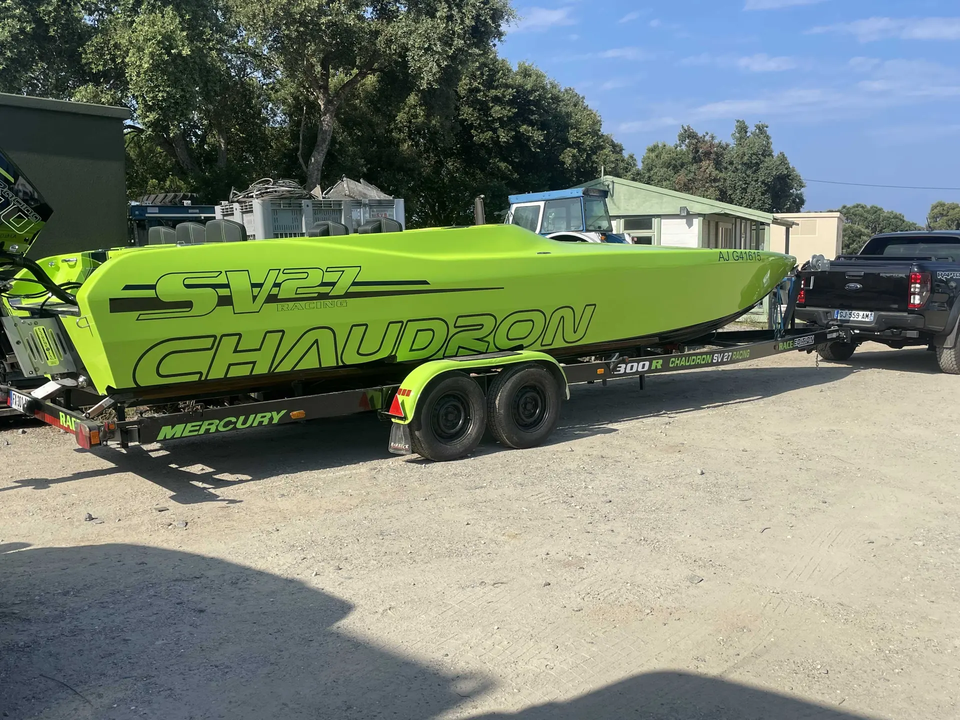 Chaudron Sv 27 Race Edition — Bateau vert présenté sur sa remorque, photographié de profil dans un espace extérieur.