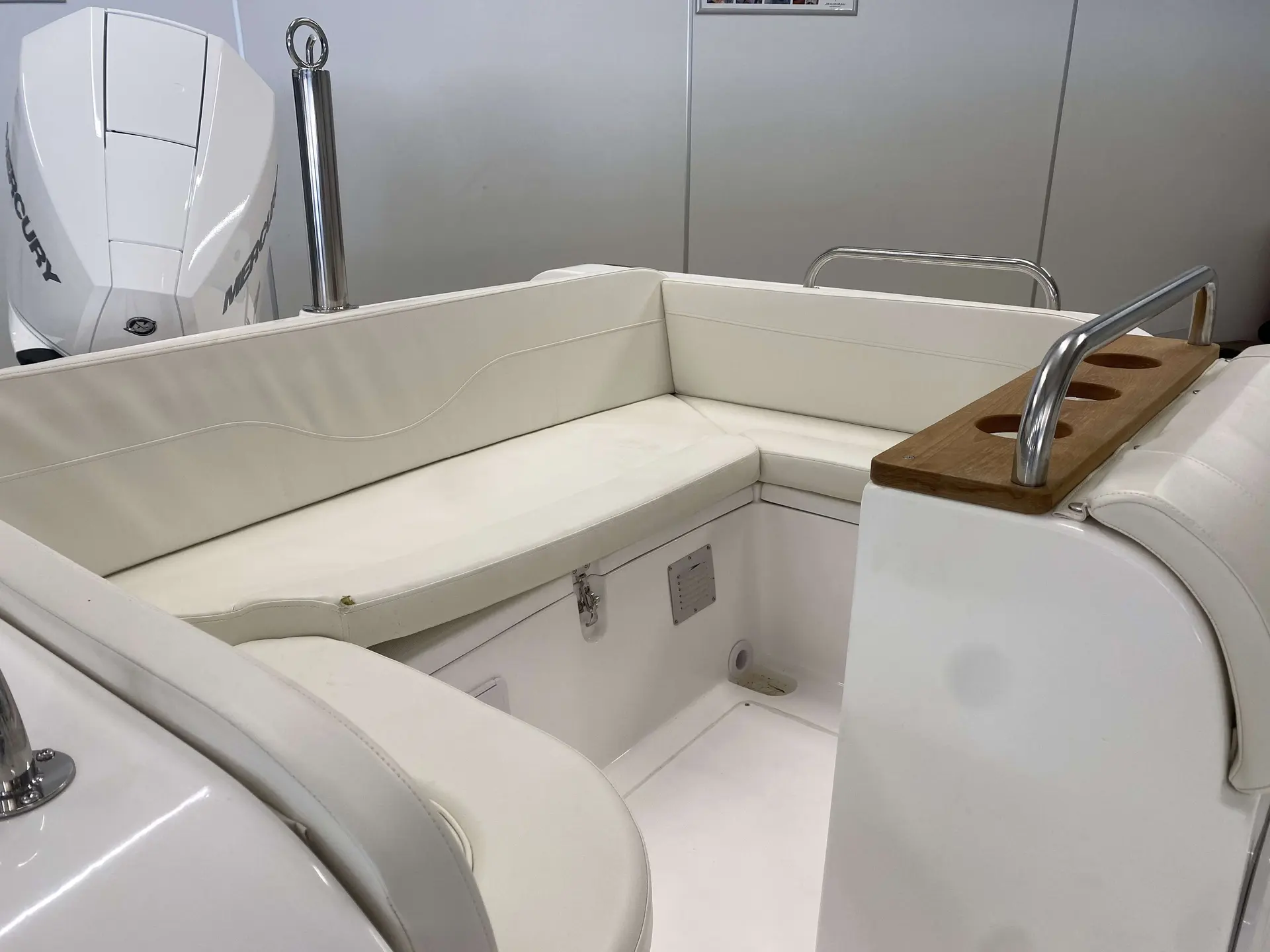 Moana 700 — Cockpit arrière avec banquettes en U, porte-gobelets et moteur hors-bord visible.