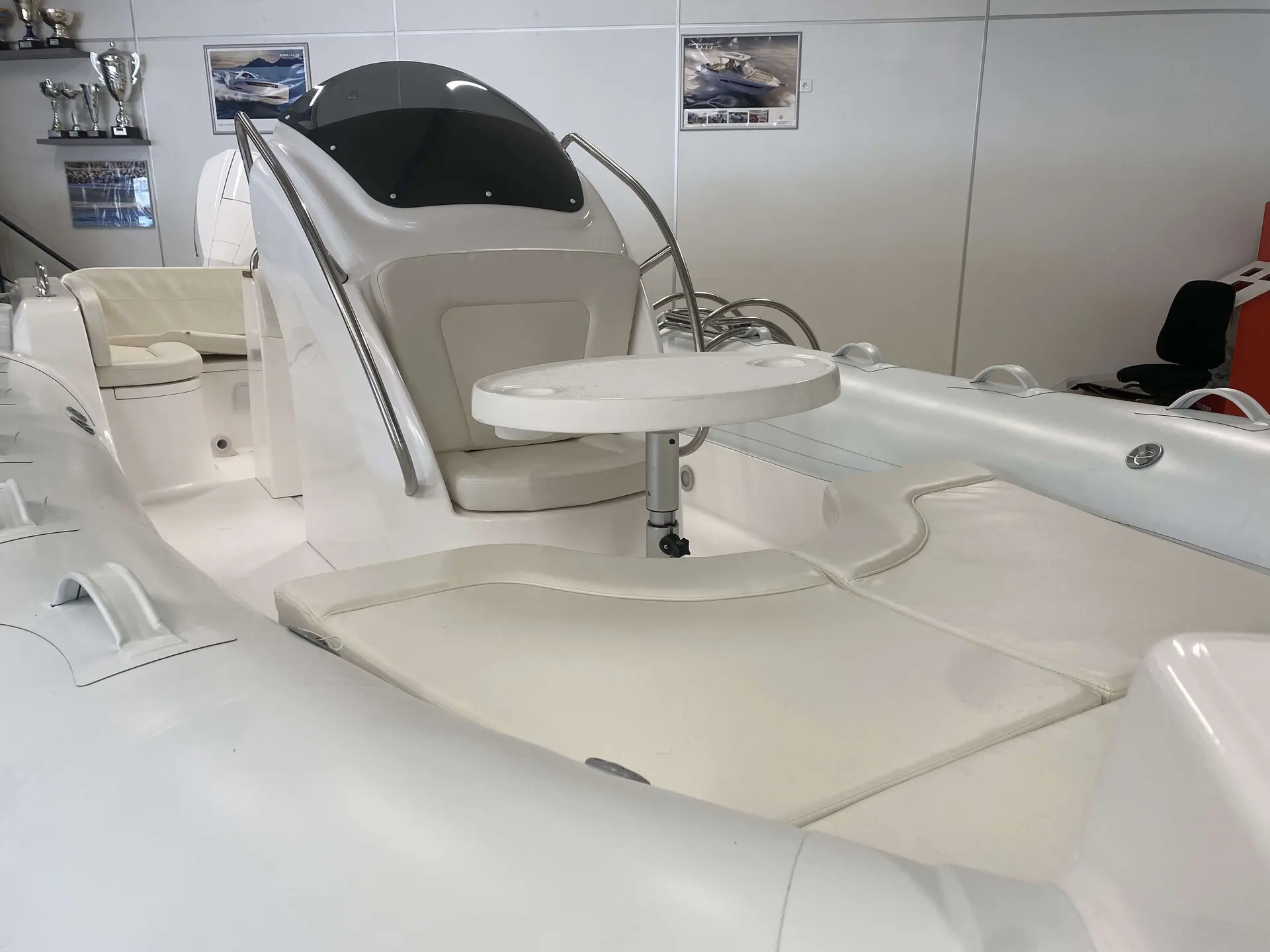Moana 700 — Vue rapprochée du cockpit et des assises avant d’un bateau en intérieur.
