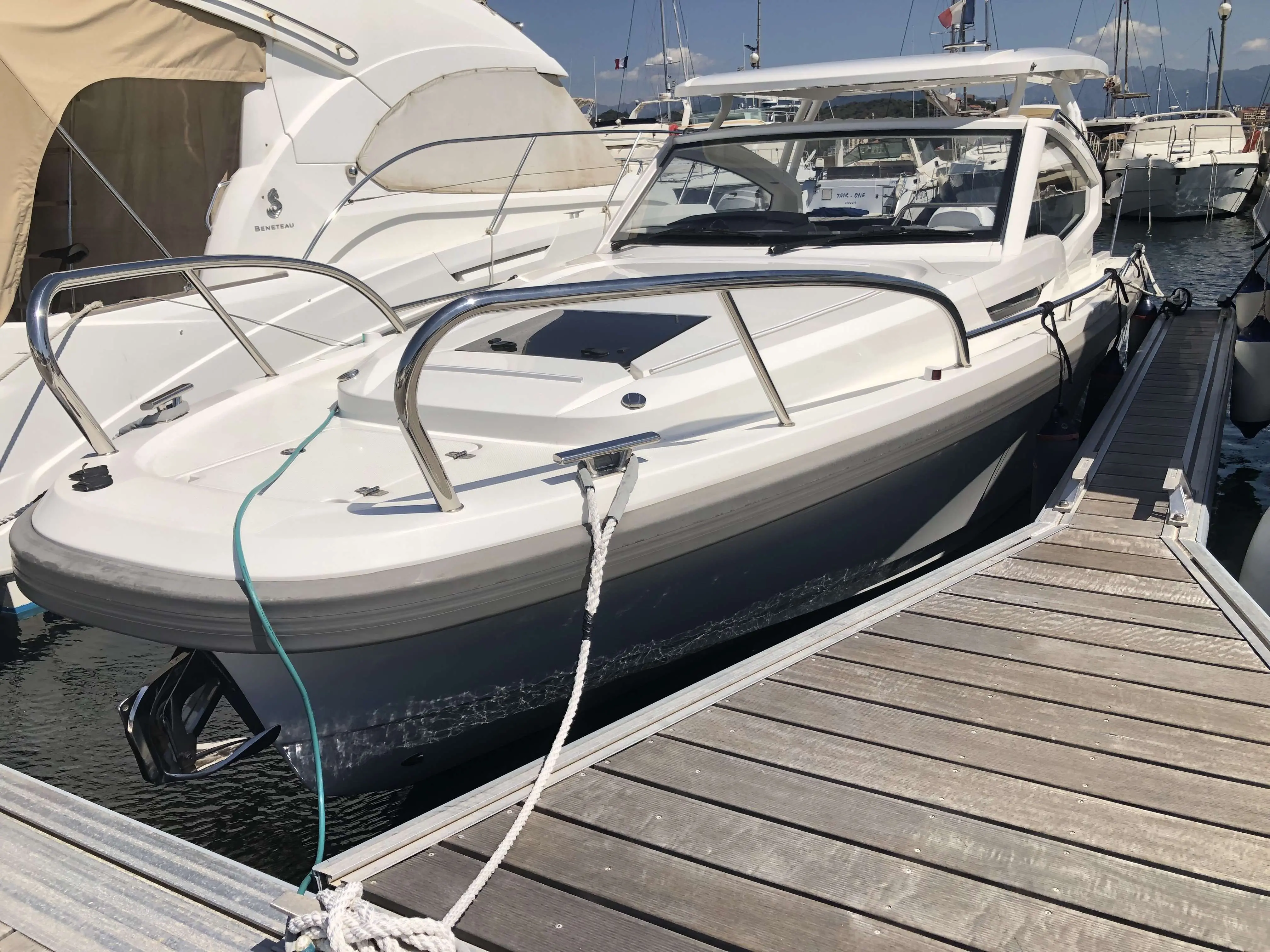 Nimbus W9 — Bateau à moteur blanc amarré dans une marina, vu de trois quarts avant.