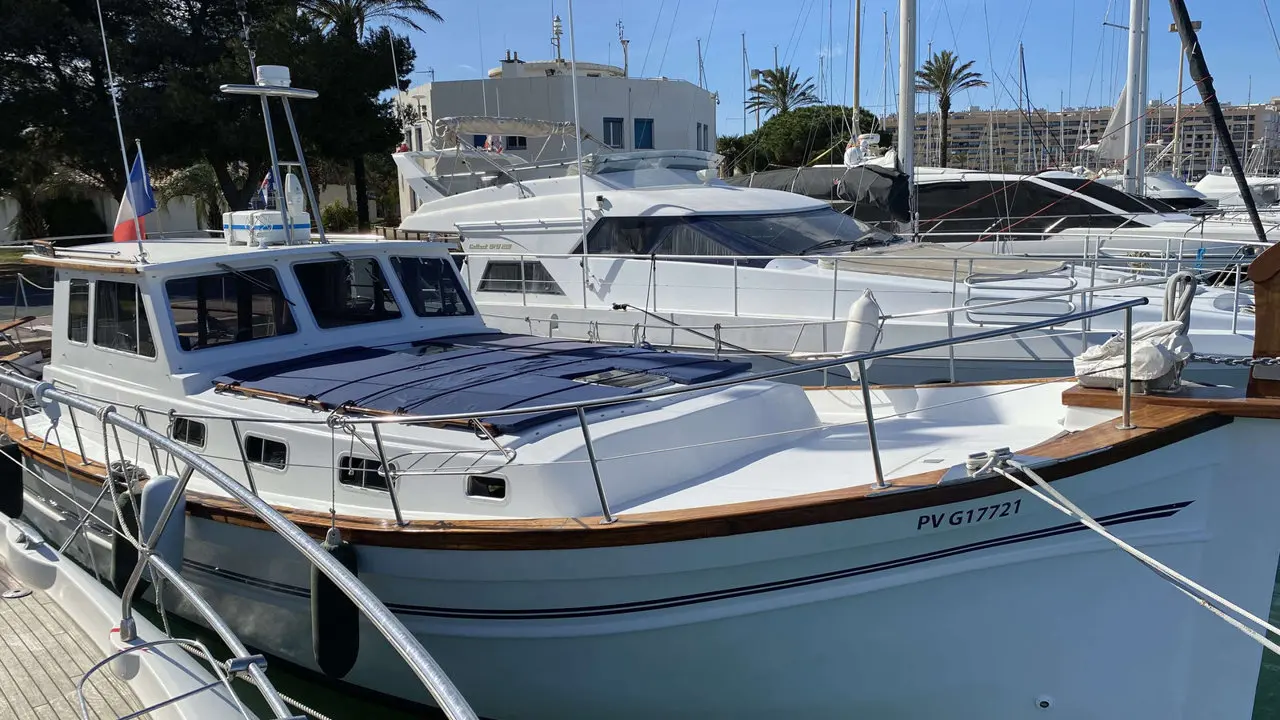 Menorquin 160 My — Bateau à moteur blanc amarré dans un port, vu de trois quarts avant.