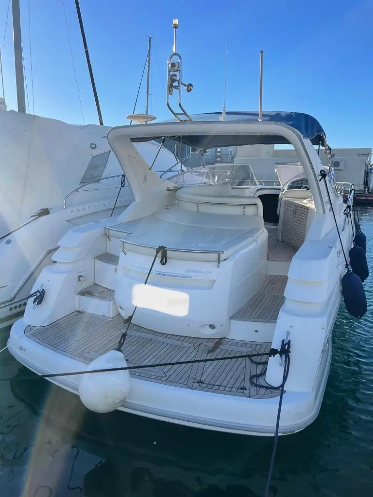 Sessa Marine Oyster 42 — Vue arrière trois quarts d’un bateau à moteur amarré, avec cockpit et plage arrière visibles.