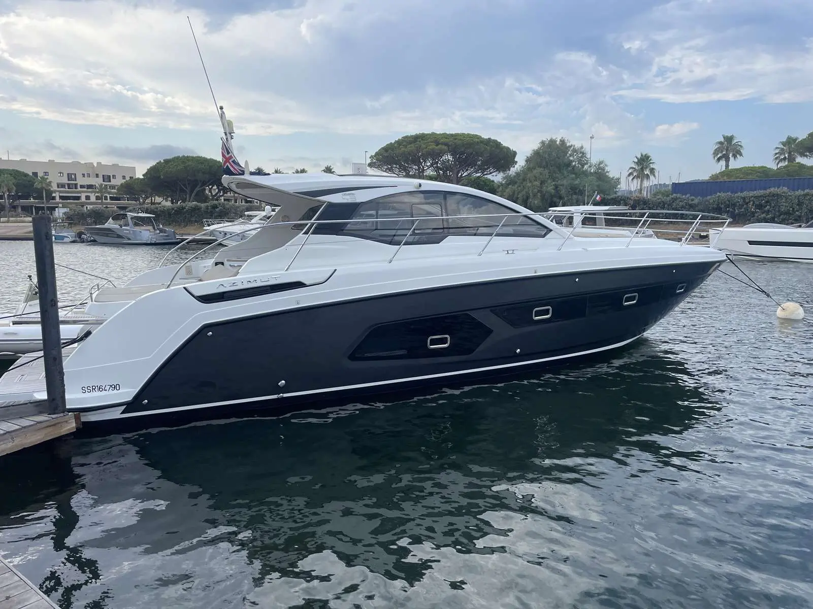 Azimut Atlantis 43 — Vue latérale d’un yacht blanc et bleu amarré dans une marina.