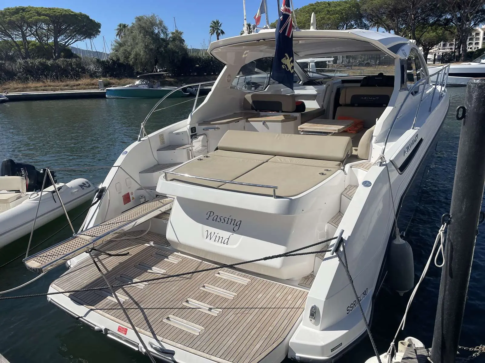 Azimut Atlantis 43 — Vue arrière trois quarts d’un bateau blanc amarré, avec bain de soleil et cockpit.
