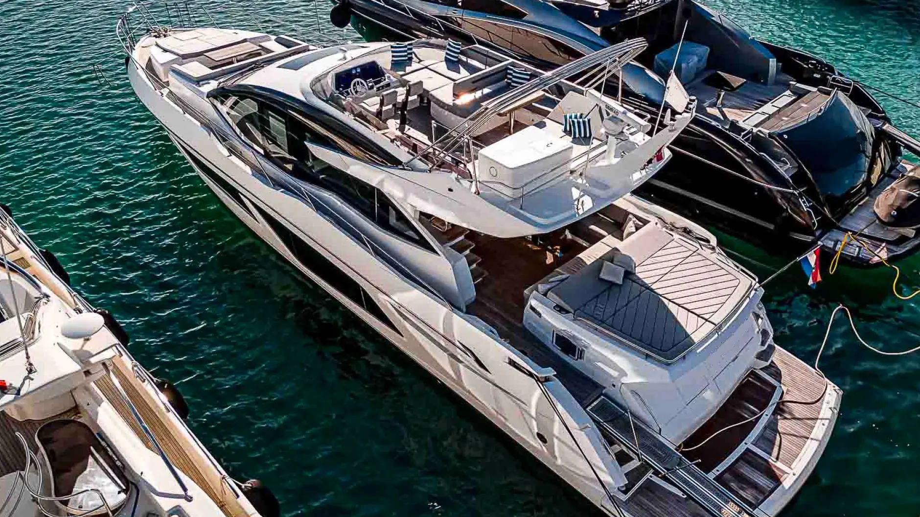 Sunseeker Sport Yacht 74 — Vue aérienne en trois-quarts d’un yacht blanc amarré dans une marina.