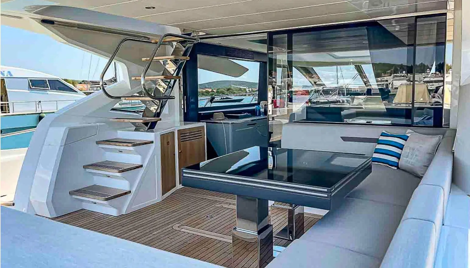 Sunseeker Sport Yacht 74 — Cockpit arrière avec salon, table et escalier vers le pont supérieur