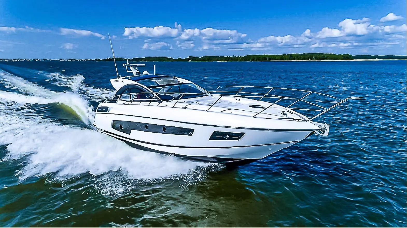Sunseeker San Remo — Bateau à moteur blanc filmé au large, naviguant à vive allure.