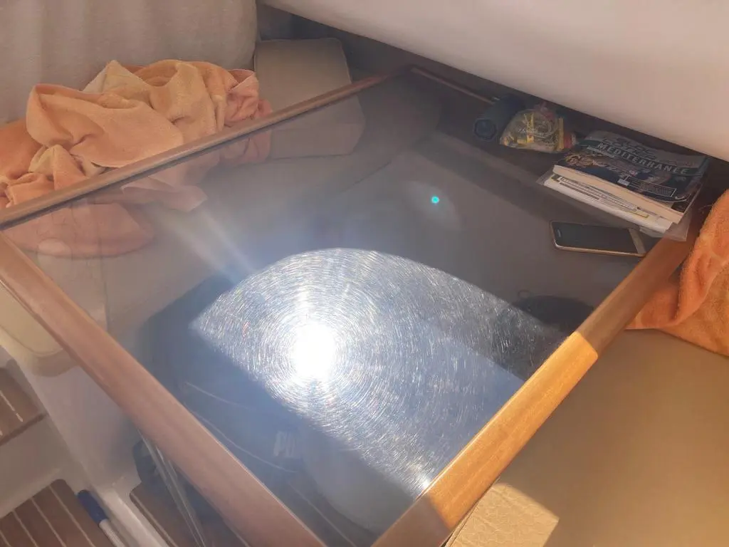 Quicksilver 650 Week-End — Vue intérieure d'une couchette encombrée, avec serviettes, livres et téléphone.