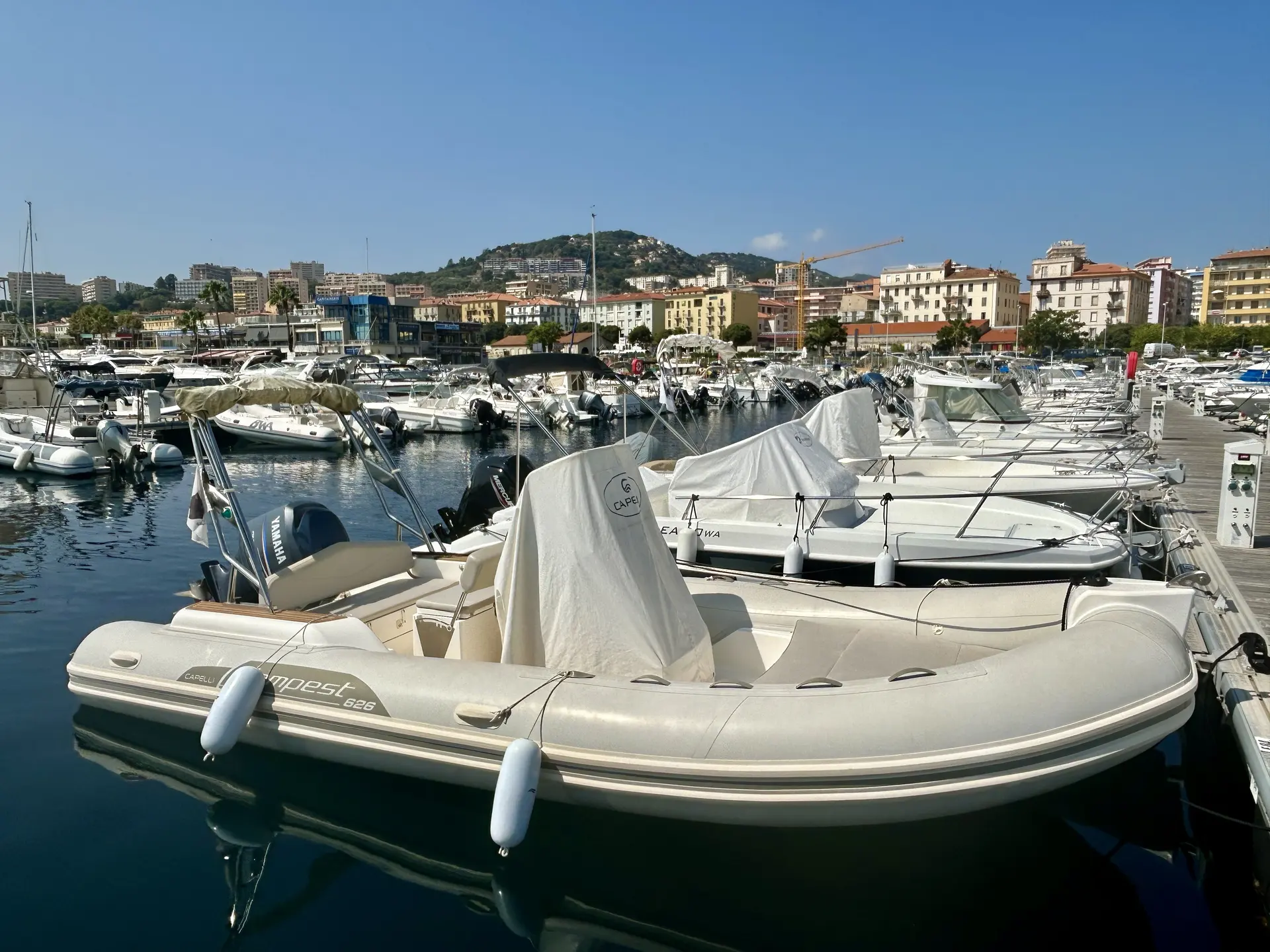 Capelli Tempest — Bateau semi-rigide amarré dans un port, avec sa console protégée par une housse.