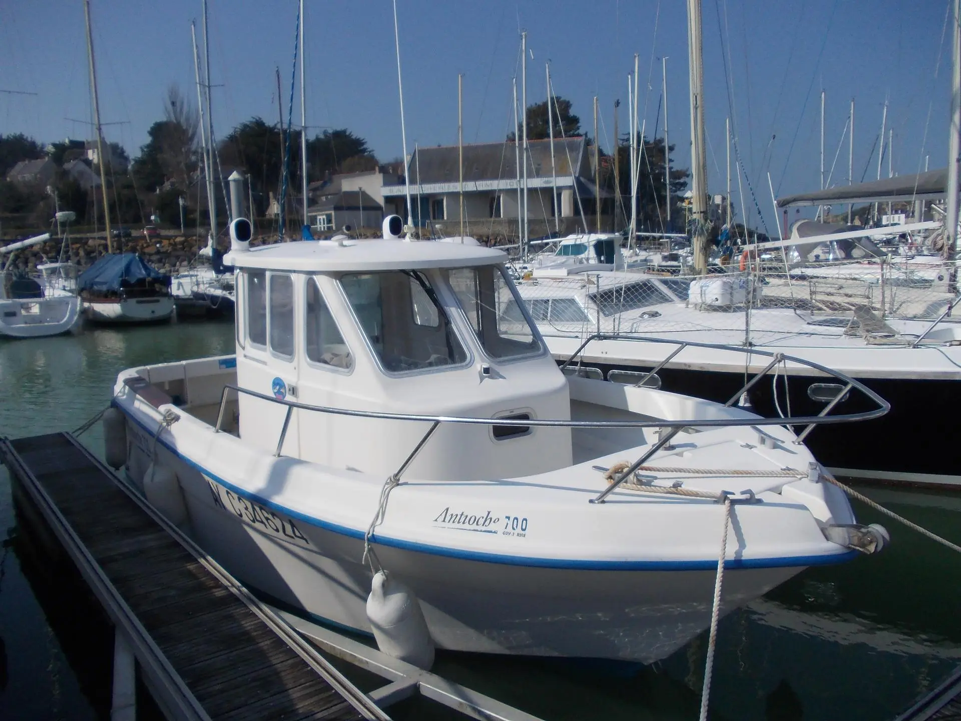 Guymarine Antioche 700 IB LA — Bateau à cabine blanc amarré dans un port de plaisance.