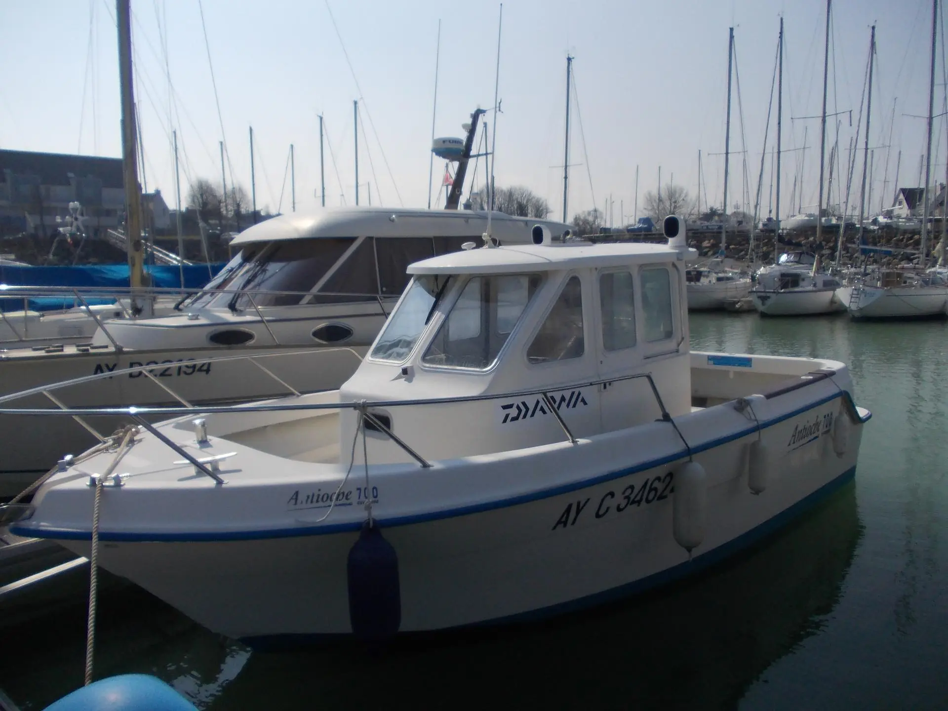 Guymarine Antioche 700 IB LA — Bateau à cabine amarré dans une marina, vu de trois quarts.