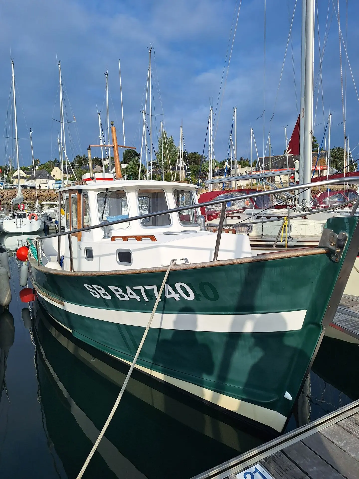 Rhea 900 — Bateau à cabine amarré dans un port, vu de trois quarts avant.