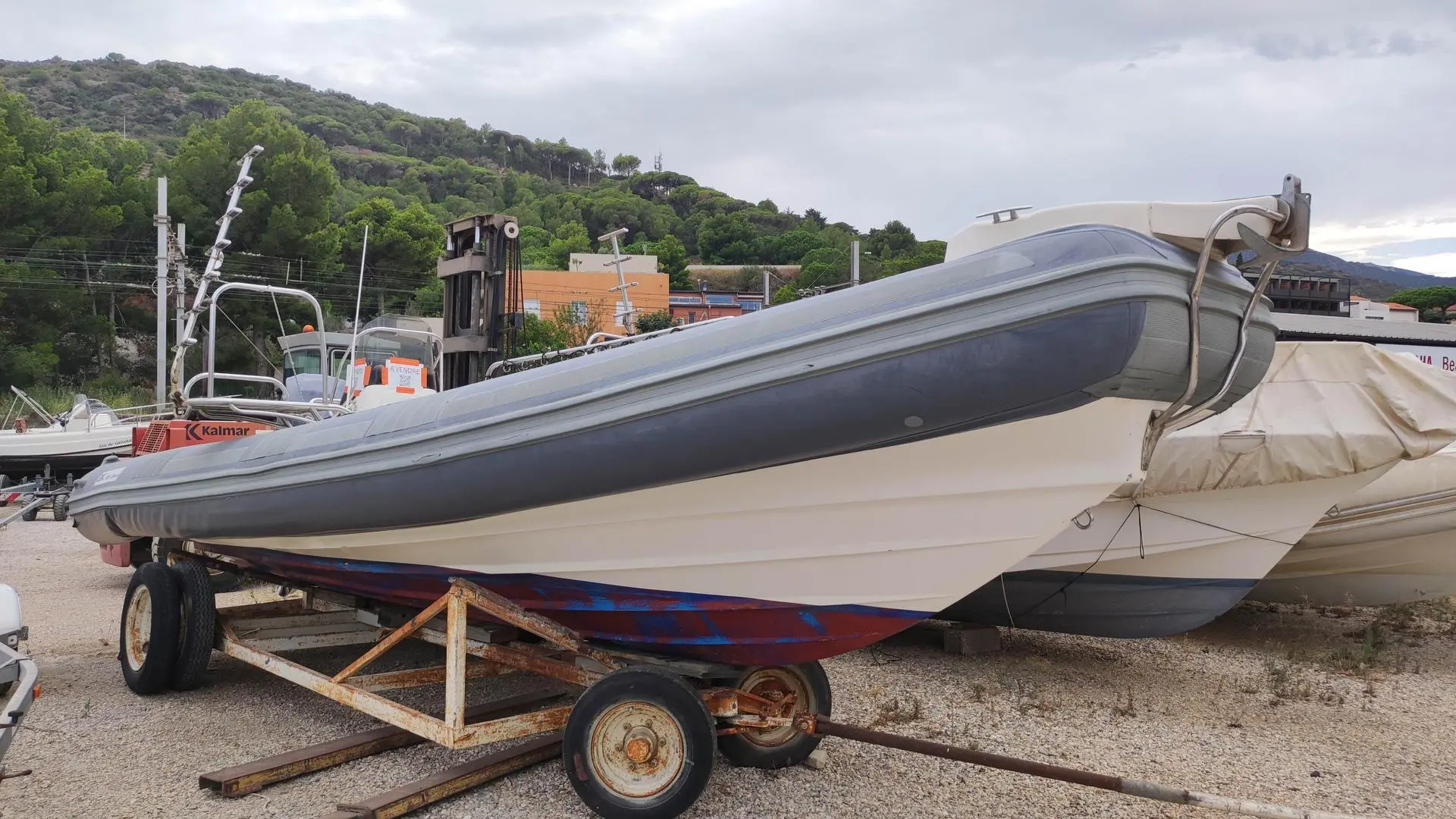 BSC 85 — Bateau pneumatique gris et blanc présenté sur une remorque dans un chantier naval.