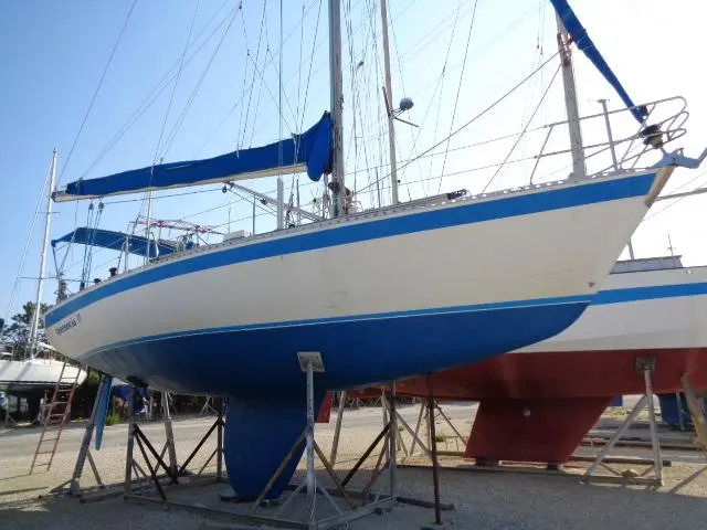 Wauquiez Centurion 38 — Voilier blanc et bleu présenté à terre sur bers, vu de trois quarts avant.