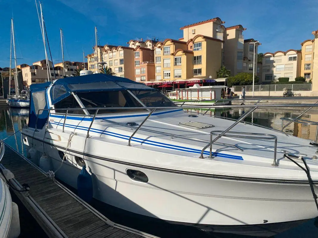 Riviera PRINCESS 286 — Bateau à moteur amarré dans une marina, vu de trois quarts avant.