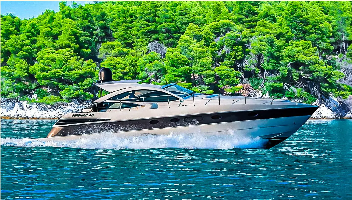 Pershing 46 — Bateau à moteur naviguant au large d'une côte boisée.
