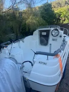 Quicksilver Activ 430 Cabin — Vue partielle de l’arrière et du poste de pilotage d’un bateau à moteur.