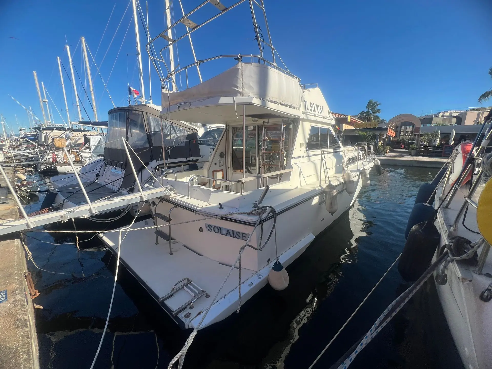 Princess 33 — Bateau à moteur blanc amarré dans une marina, vu de trois quarts arrière.