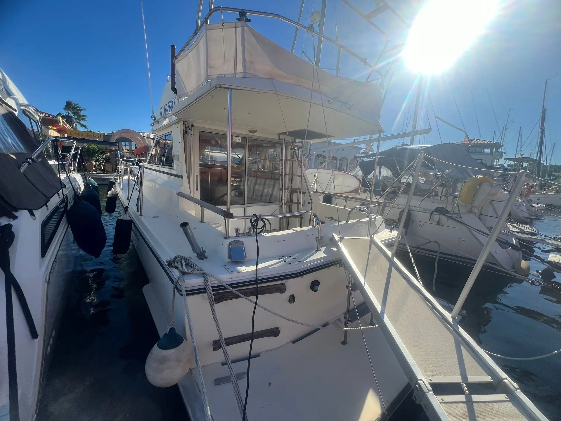Princess 33 — Bateau à moteur blanc amarré dans une marina, vu depuis l’arrière bâbord.