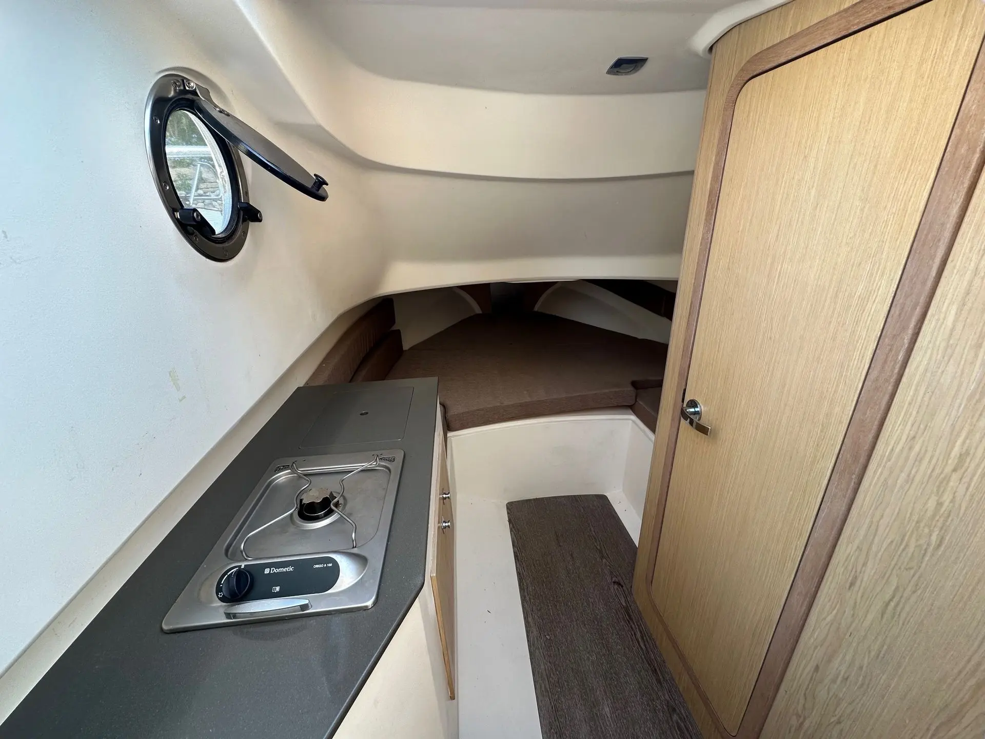 Capelli 850 — Vue intérieure avec kitchenette, porte en bois et couchette avant.
