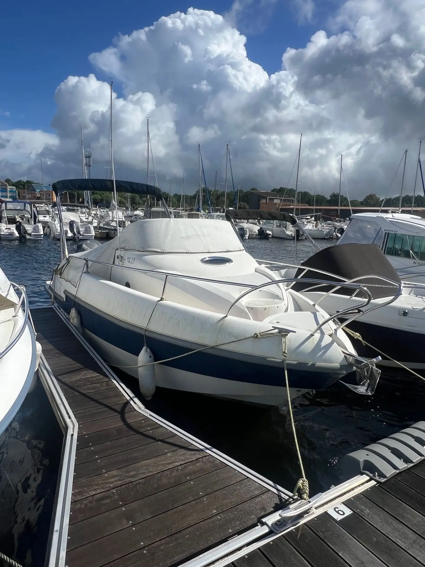 Lexsia XS23 — Bateau à moteur amarré dans une marina, photographié de trois quarts avant.