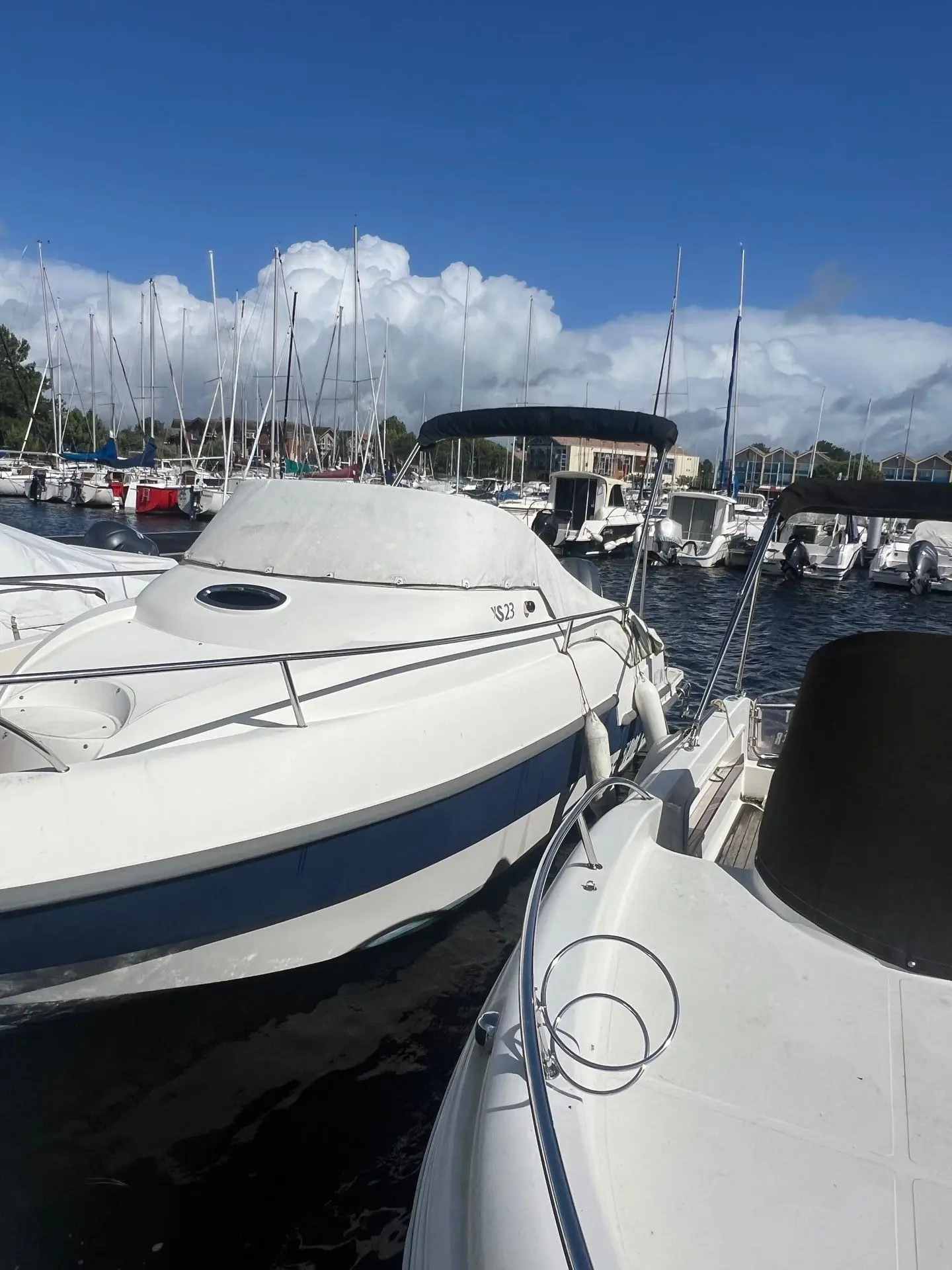 Lexsia XS23 — Bateau à moteur amarré dans une marina, vu de trois quarts avant.