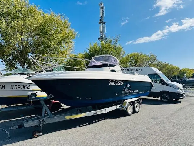 Ultramar 650 Winner — Bateau à moteur bleu et blanc sur remorque, photographié de trois quarts sur un parking.