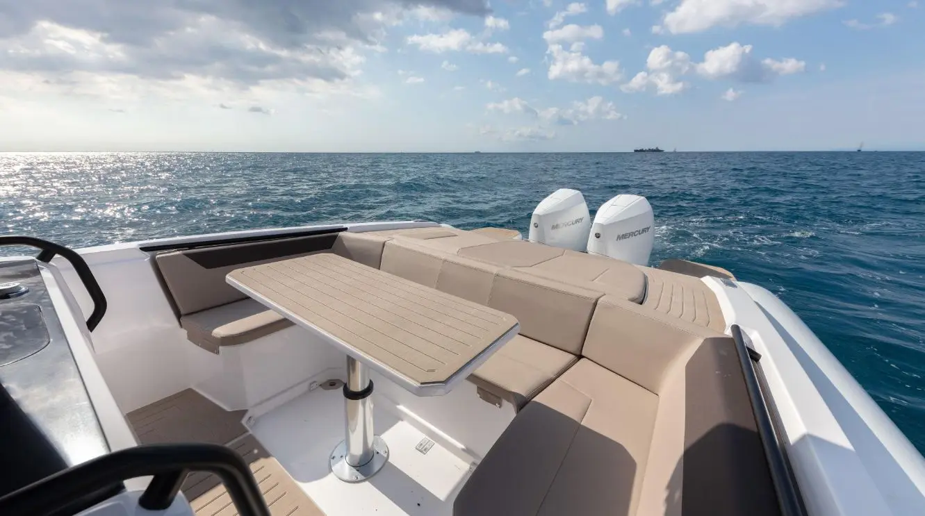Rio Yachts Inagua — Vue du cockpit arrière avec table, banquettes et deux moteurs hors-bord.