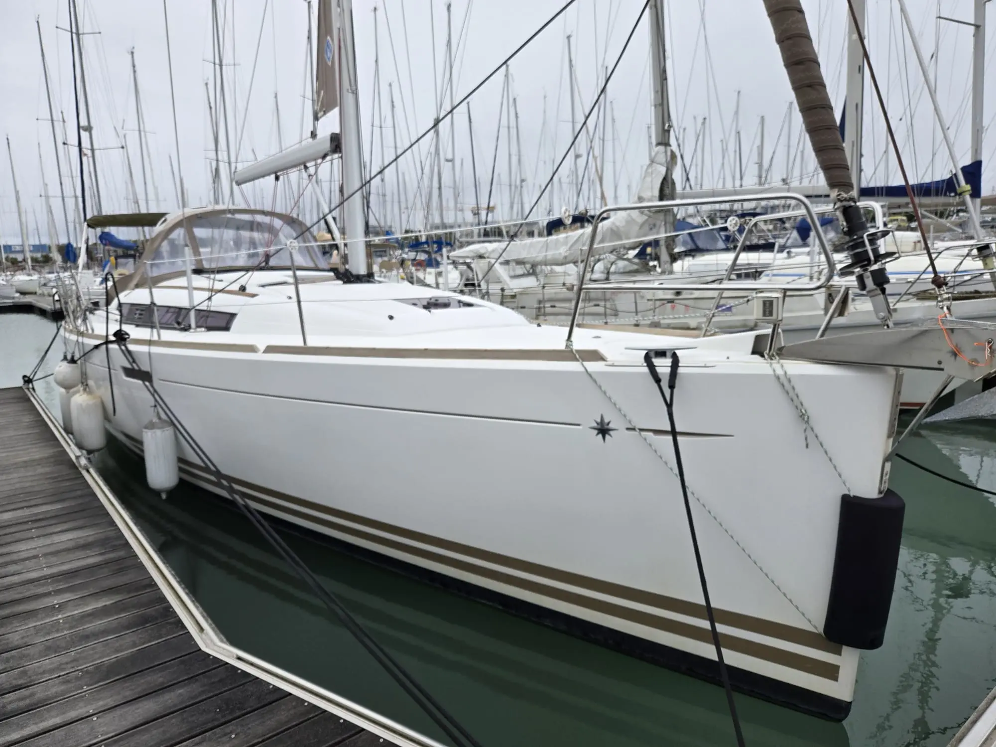 Jeanneau Sun Odyssey 379 — Voilier blanc amarré au ponton dans une marina, vu de trois quarts avant.