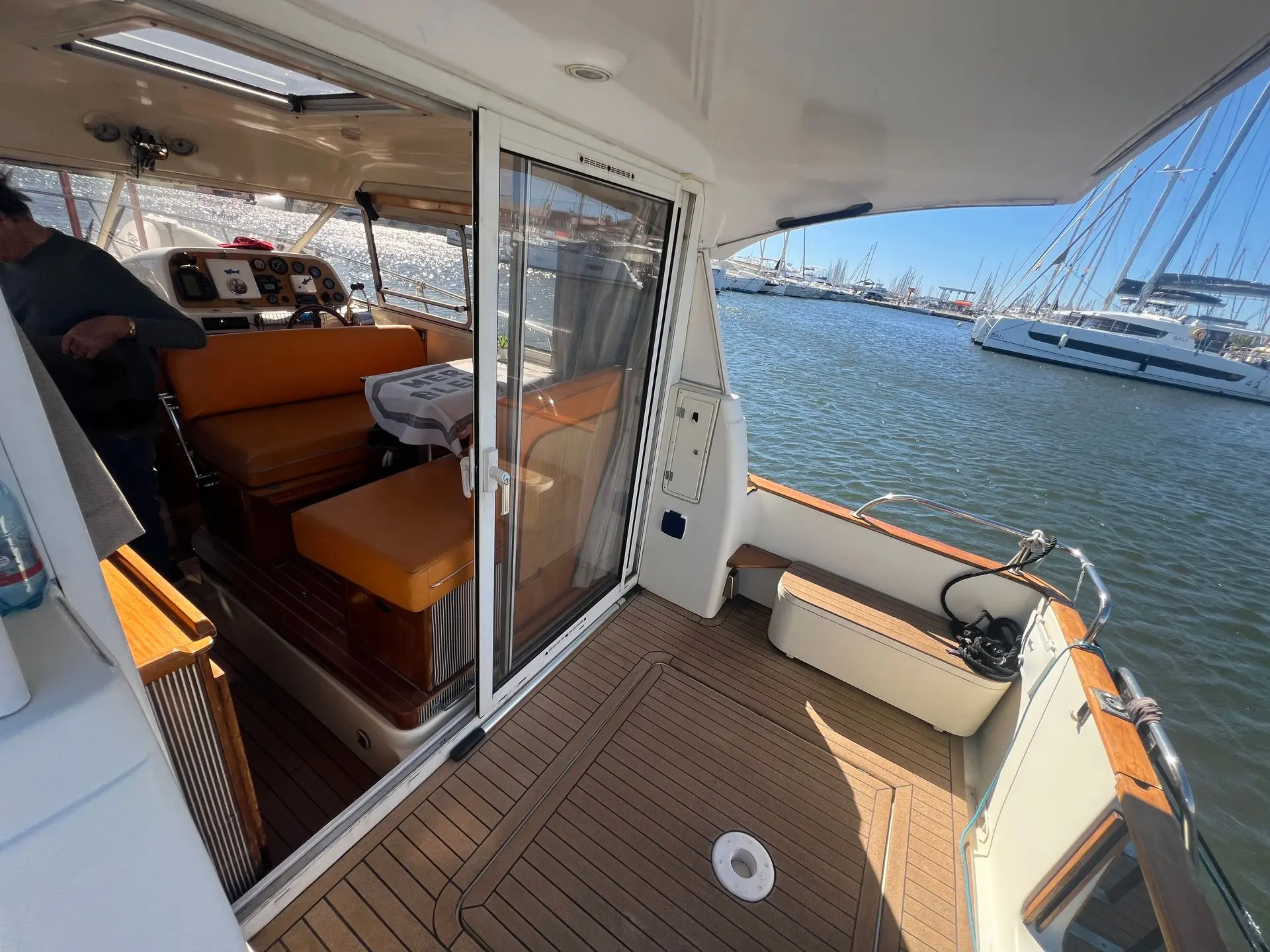 ACM Heritage 26 — Vue du cockpit arrière et du carré d’un bateau à quai.