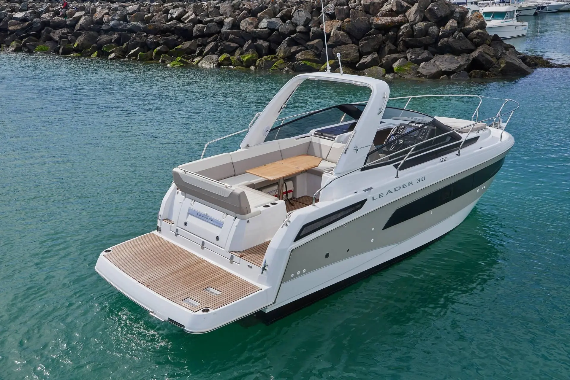 Jeanneau Leader 30 — Bateau à moteur blanc vu de trois quarts arrière dans un port.