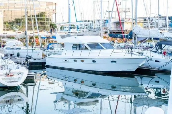Doqueve 410 — Bateau à moteur blanc amarré dans une marina, vu de trois quarts.