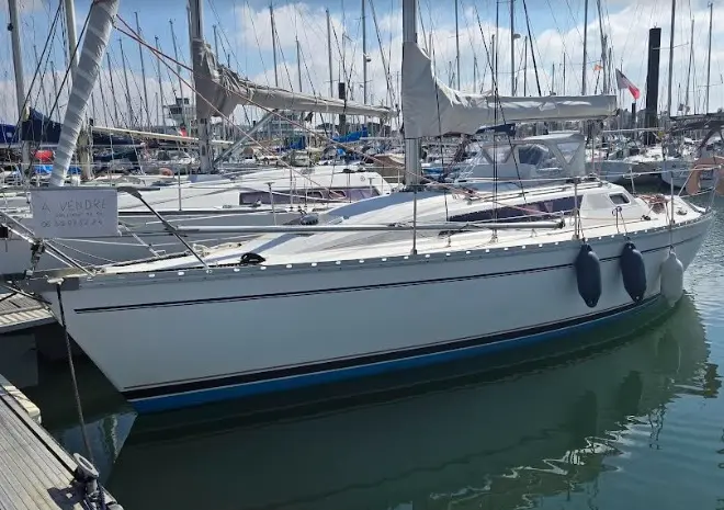Jeanneau Sun Light 30 — Voilier blanc amarré dans un port, vu de profil depuis le quai.