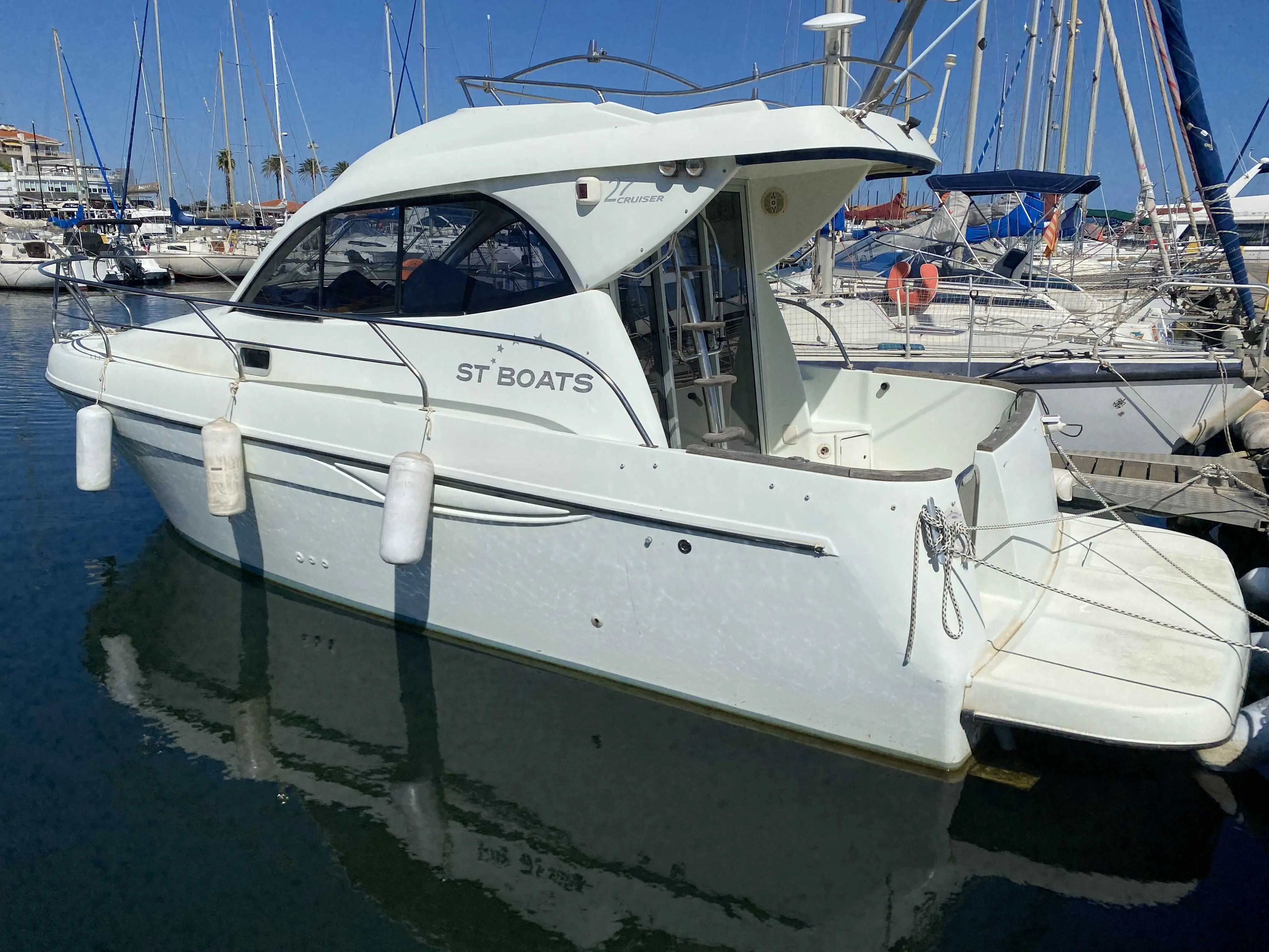 ST Boats 27 — Bateau à moteur blanc amarré dans un port de plaisance, vu de trois quarts.