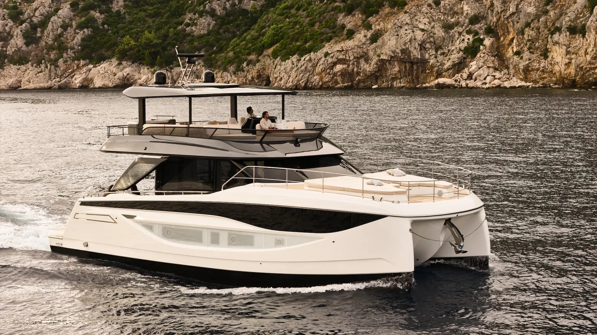 Prestige Yachts M7 — Vedette à moteur blanche naviguant devant une côte rocheuse.