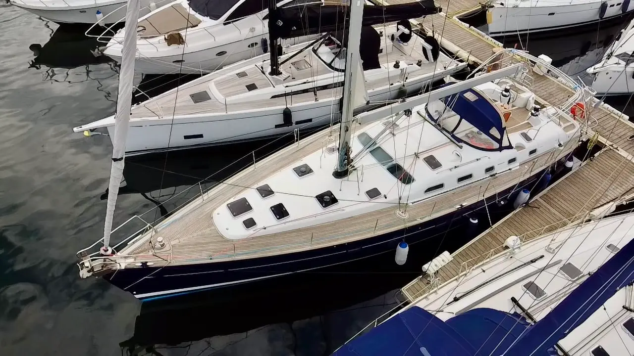 Beneteau Oceanis 523 — Voilier vu de trois quarts amarré dans une marina, entouré d'autres bateaux.