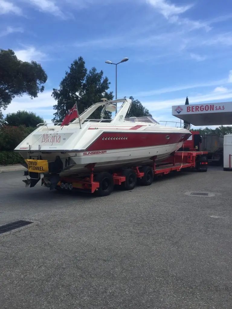 Sunseeker Thunderhawk 43 — Bateau à moteur blanc et rouge sur remorque, photographié à terre.