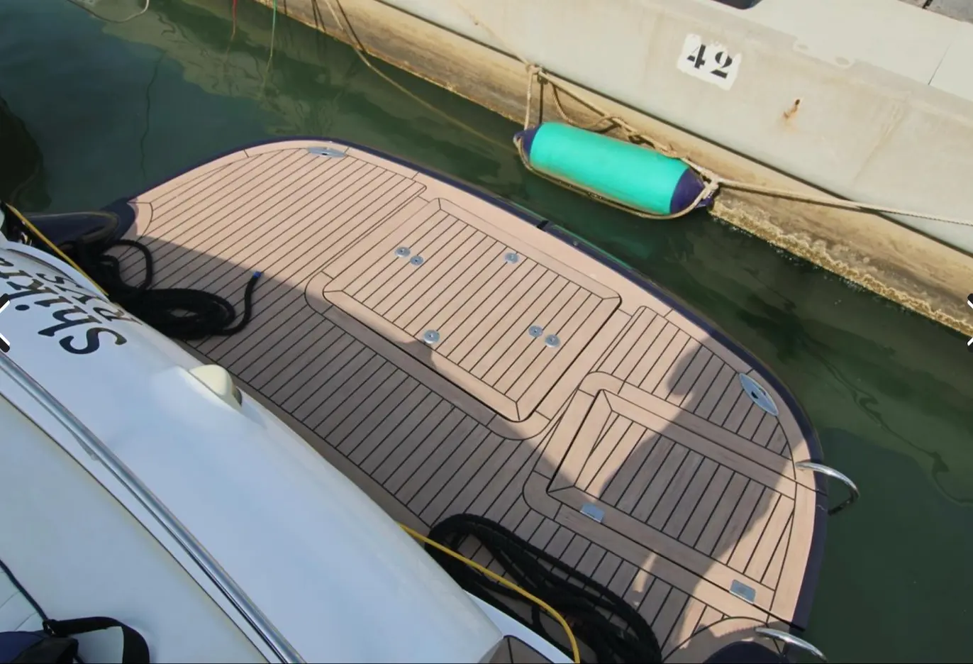 Sunseeker Superhawk 50 — Vue plongeante partielle de la plateforme arrière d’un bateau amarré au quai.