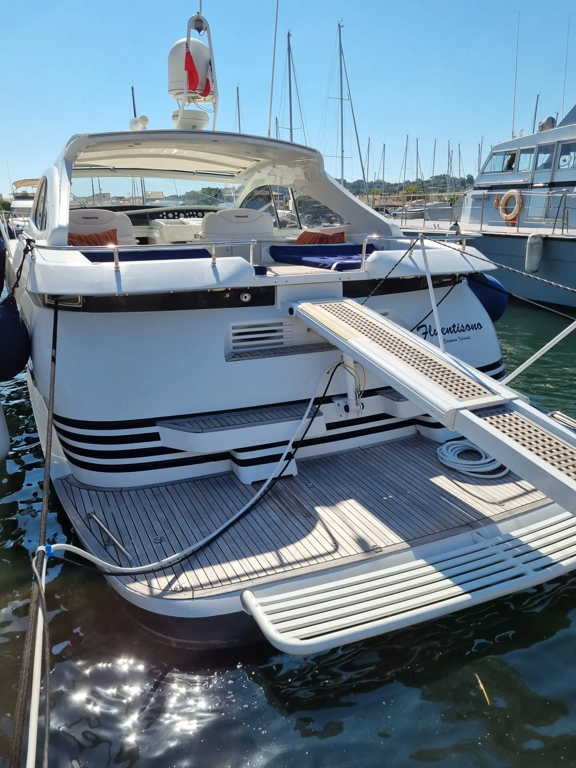 Pershing 54 — Yacht vu de trois-quarts arrière, amarré, avec cockpit et plateforme arrière visibles.