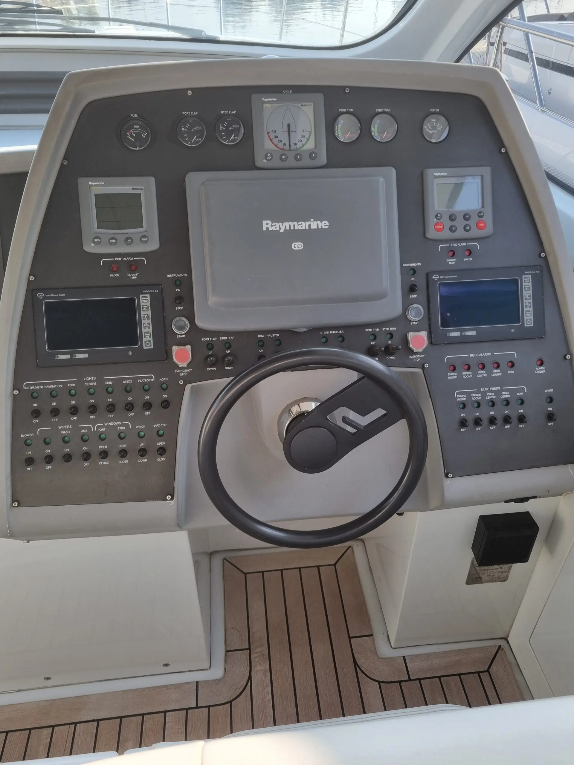 Pershing 56 HT — Poste de pilotage avec instruments, écrans de navigation et commandes à la barre.
