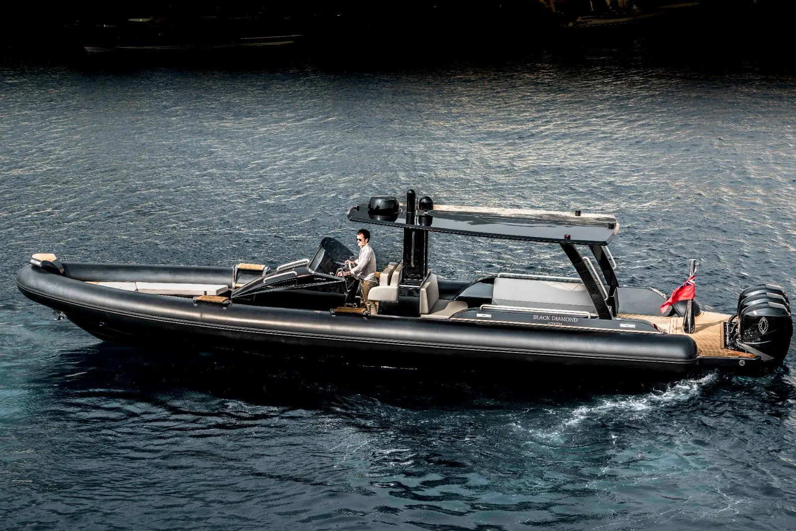 Dariel DTS — Bateau pneumatique semi-rigide noir naviguant sur l’eau, vu de profil.
