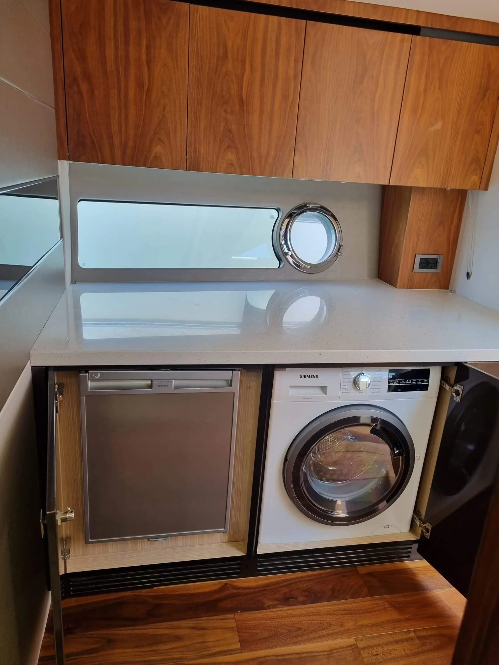 Sunseeker Predator 57 — Espace intérieur avec lave-vaisselle, lave-linge, rangements et hublot.