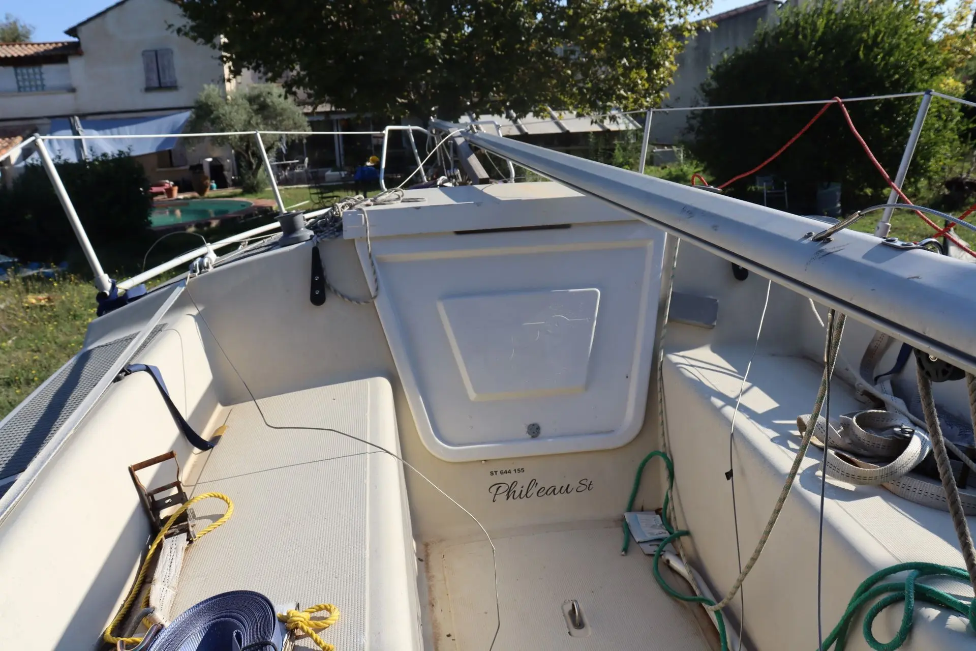 Etap 20 — Vue du cockpit arrière d’un voilier, avec sa barre, ses cordages et son capot.