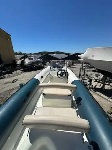 Zodiac Bombard Sunrider 650 — Vue intérieure d’un semi-rigide bleu et blanc stationné dans un chantier nautique.