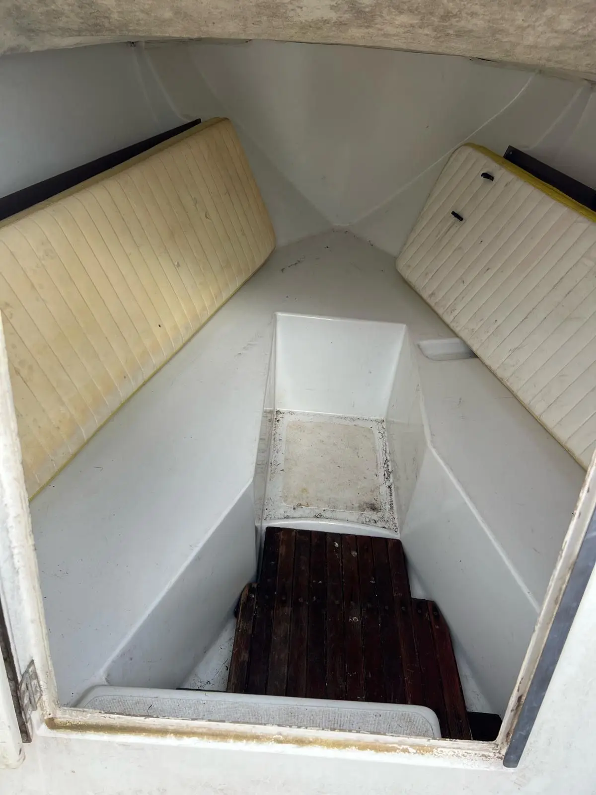 Ocqueteau Colt 540 — Vue intérieure d’un bateau avec deux banquettes et un plancher en bois.