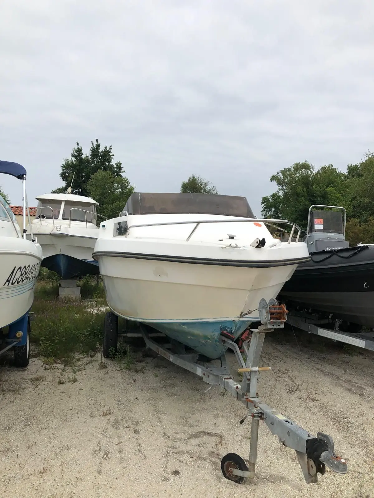 Ocqueteau Colt 540 — Bateau à moteur blanc sur remorque, photographié de face dans un parc nautique.