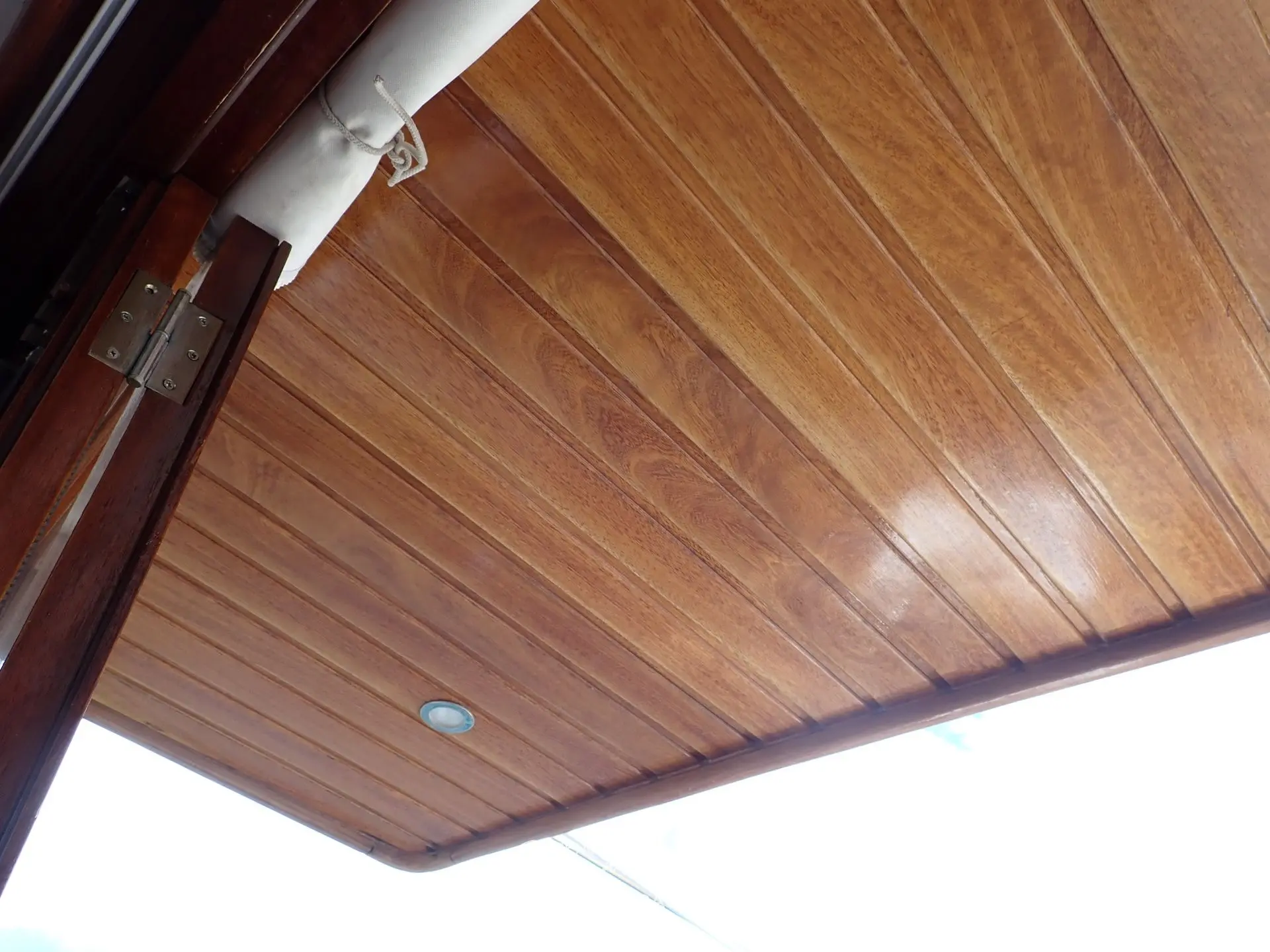 Menorquin 160 — Vue rapprochée d’un plafond en bois avec plafonnier et éléments de structure.